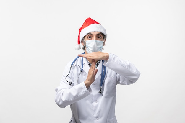 Vue avant de l'homme médecin avec masque sur un mur blanc virus pandémique vacances covid