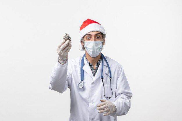 Vue avant de l'homme médecin tenant le cône sur le mur blanc virus santé covid- Noël