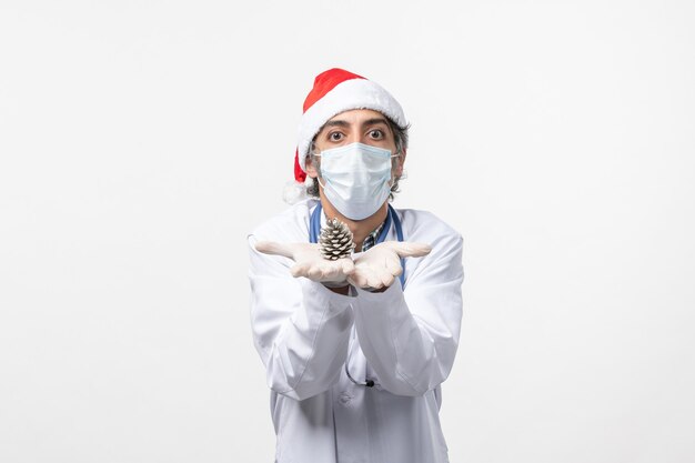 Vue avant de l'homme médecin tenant le cône sur le mur blanc virus santé covid- Noël
