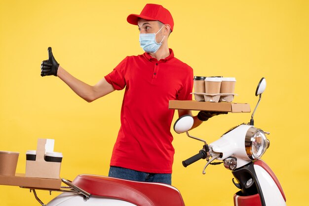 Vue avant de l'homme de messagerie en uniforme avec café et nourriture fort sur jaune travail de service de pandémie de travail covid- couleur du virus de l'emploi