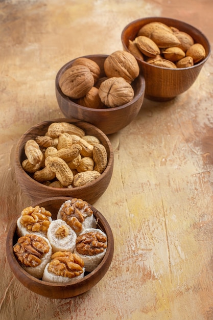 Vue avant des noix fraîches à l'intérieur des plaques sur le bureau en bois noisette d'arachide écrou