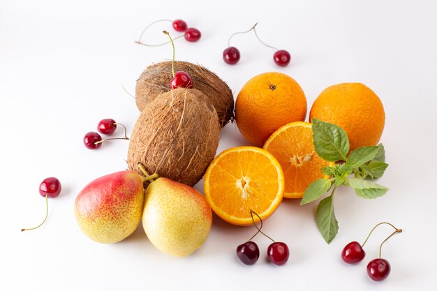 Vue avant d'oranges entières fraîches juteuses et aigres avec des noix de coco et des cerises sur blanc