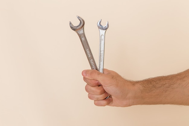 Photo gratuite vue avant des outils d'argent tenir par l'homme sur l'outil de l'instrument de bureau léger mâle