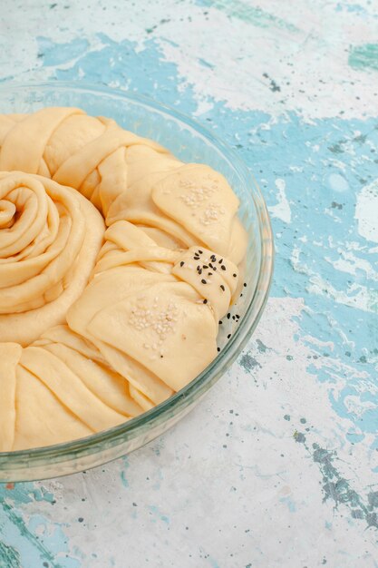 Vue avant de la pâte à tarte crue ronde formée sur la tarte de bureau bleu biscuit gâteau cru sucré