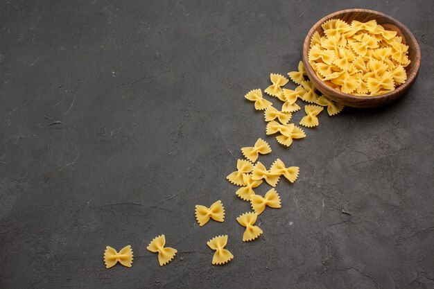 Vue avant des pâtes italiennes crues sur table sombre repas de pâtes crues