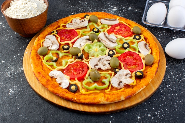 Vue avant pizza aux champignons aux tomates rouges poivrons, olives et champignons tous tranchés à l'intérieur avec des œufs et de la farine sur fond gris