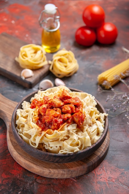 Vue avant de poulet avec plat de pâtes de pâte sur plat de pâte de surface sombre pâtes foncées