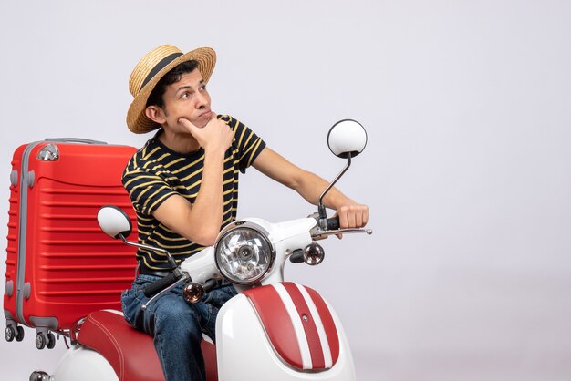 Vue avant réfléchie jeune homme avec chapeau de paille sur cyclomoteur