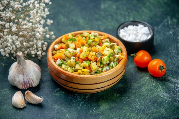 Vue avant de la salade de légumes bouillis mélangés à l'intérieur de la plaque ronde sur fond sombre