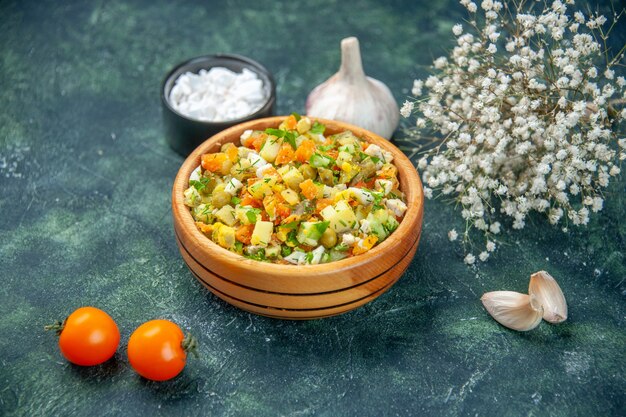 Vue avant de la salade de légumes bouillis mélangés à l'intérieur de la plaque ronde sur fond sombre