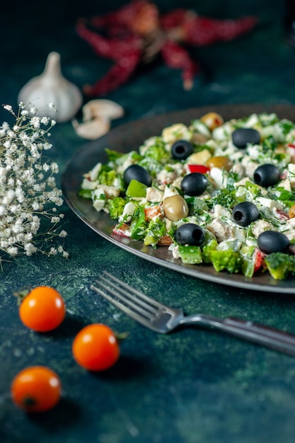 Vue avant salade de légumes avec de la mayyonaise et des olives sur la surface bleu foncé repas plat de vacances photo couleur dîner