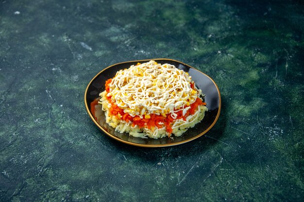 Vue avant salade mimosa avec des oeufs de pommes de terre et de poulet à l'intérieur de la plaque sur la surface bleu foncé vacances anniversaire photo cuisine cuisine couleur cuisine