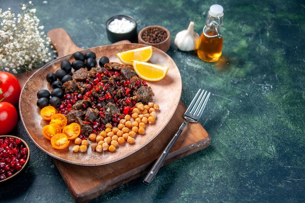 Vue avant de savoureuses tranches de viande frit avec des raisins et des haricots à l'intérieur de la plaque sur fond sombre