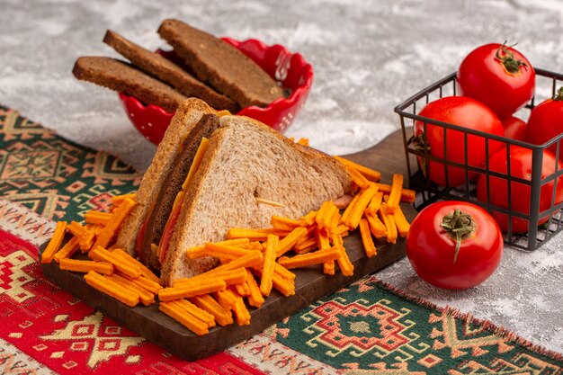 Vue avant de savoureux sandwich au pain grillé avec du jambon au fromage avec des frites pain de tomates sur blanc