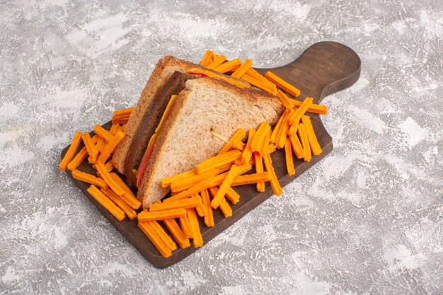 Vue avant de savoureux sandwich au pain grillé avec jambon au fromage avec frites sur blanc