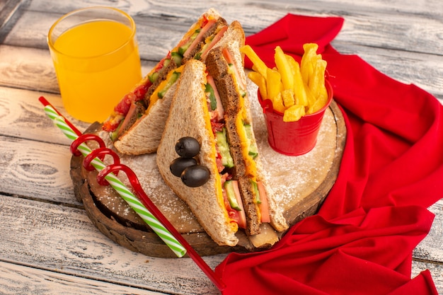 Vue avant de savoureux sandwichs au pain grillé avec du jambon au fromage à l'intérieur avec du jus de frites tissu rouge sur bois