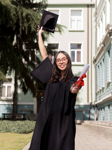 Vue avant, smiley, jeune femme, porter, graduation, robe