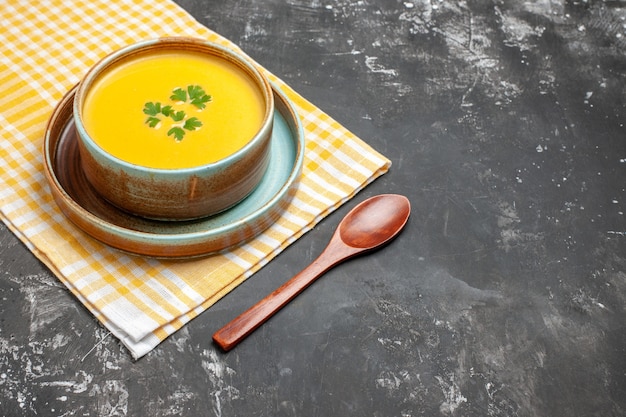 Vue avant de la soupe à la citrouille à l'intérieur de la plaque sur la table sombre