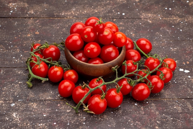 Vue avant de tomates fraîches rouges sur bois brun