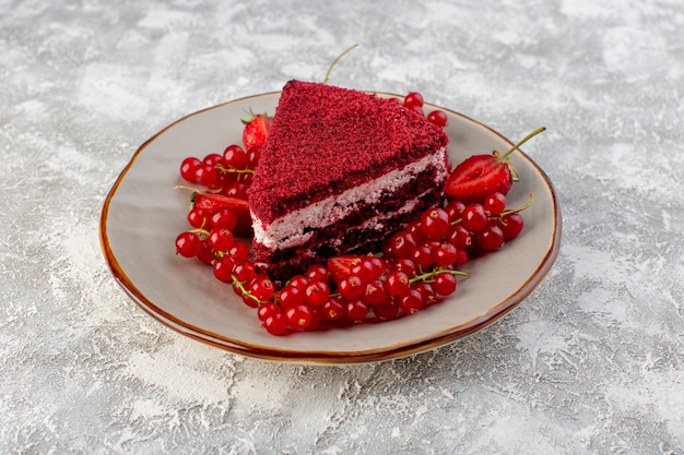 Photo gratuite vue avant tranche de gâteau rouge morceau de gâteau aux fruits à l'intérieur de la plaque avec des canneberges fraîches sur fond gris