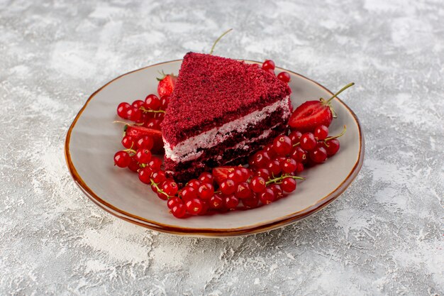 Vue avant tranche de gâteau rouge morceau de gâteau aux fruits à l'intérieur de la plaque avec des canneberges fraîches sur fond gris