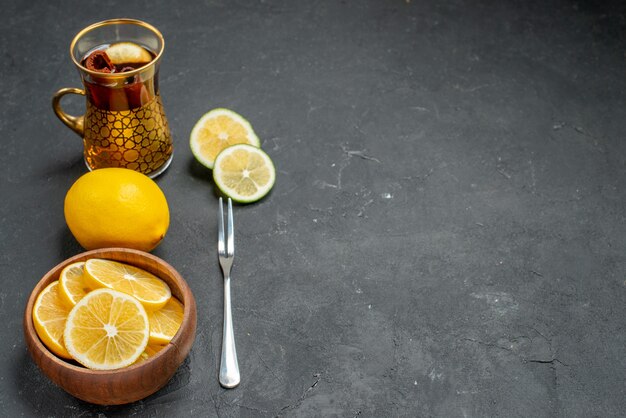 Vue avant des tranches de citron frais avec du thé sur fond sombre