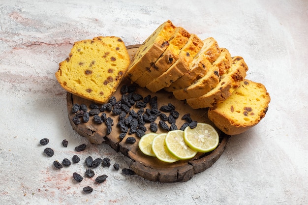 Photo gratuite vue avant des tranches de gâteau délicieux avec des raisins secs et des tranches de citron sur une surface blanche