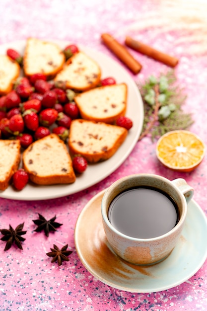 Vue avant des tranches de gâteau avec des fraises fraîches et du café sur le gâteau de bureau rose cuire au four biscuit sucré couleur tarte biscuit au sucre