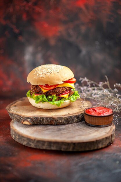 Vue avant de la viande hamburger avec salade de fromage et de tomates sur un bureau sombre sandwich fast-food