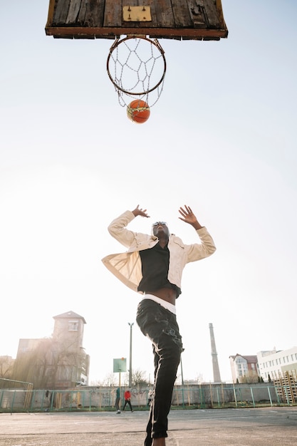 Vue de bas adolescent jouant au basket-ball à l'extérieur