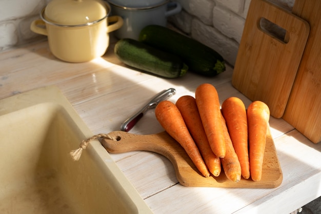 Photo gratuite vue des carottes sur une planche à découper dans la cuisine