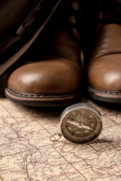 Vue de la carte de voyage du monde avec chaussures et boussole