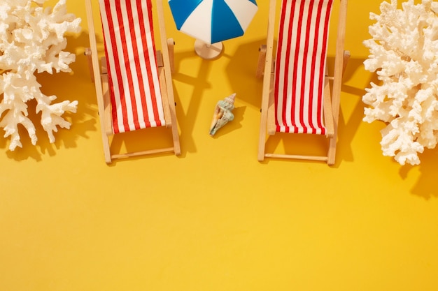 Photo gratuite vue des chaises de plage d'été avec parasol