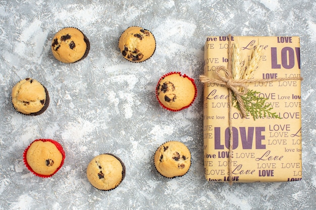 Vue ci-dessus de délicieux petits gâteaux au chocolat et cadeau avec inscription d'amour sur la surface de la glace