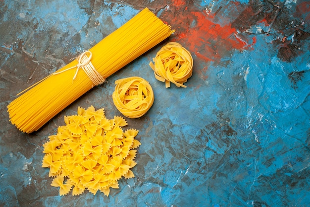 Vue ci-dessus de diverses pâtes italiennes pour la préparation du dîner sur fond bleu