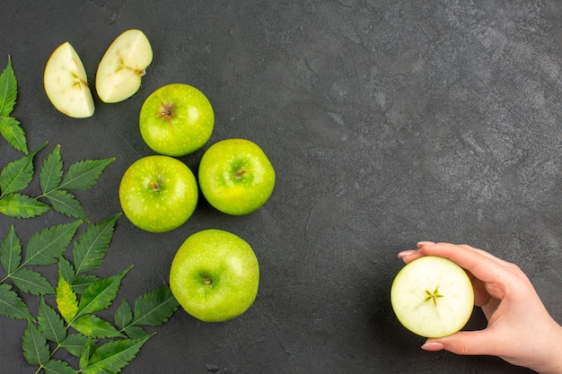 Vue ci-dessus de pommes vertes fraîches entières et hachées et de menthe sur fond noir