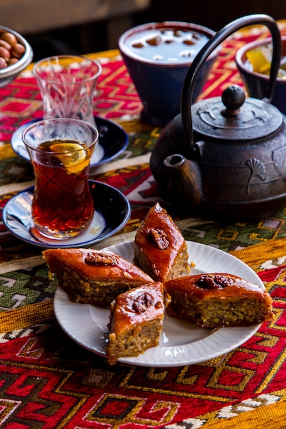 Vue de côté baklava azerbaïdjanais douceur traditionnelle aux noix avec un verre de thé