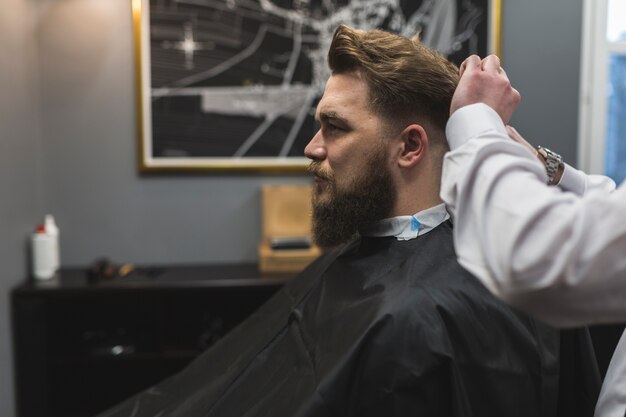 Vue de côté barber couper les cheveux du client