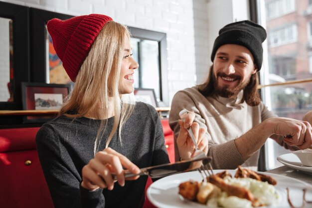 Vue côté, de, couple souriant, manger, dans, café