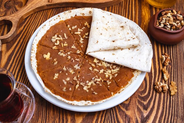 Vue de côté du thé lavash aux noix halva traditionnelles