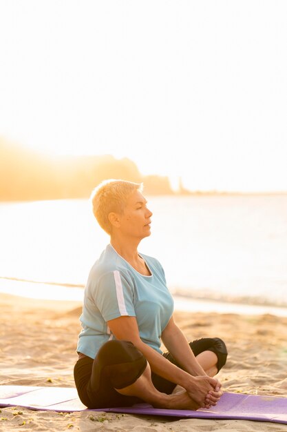 Vue côté, de, femme aînée, faire, yoga, plage