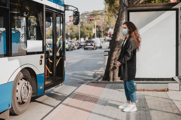 Photo gratuite vue côté, femme, attente, pour, les, bus