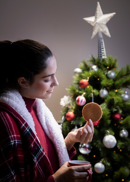 Photo gratuite vue côté, femme, boire thé, manger, cookie