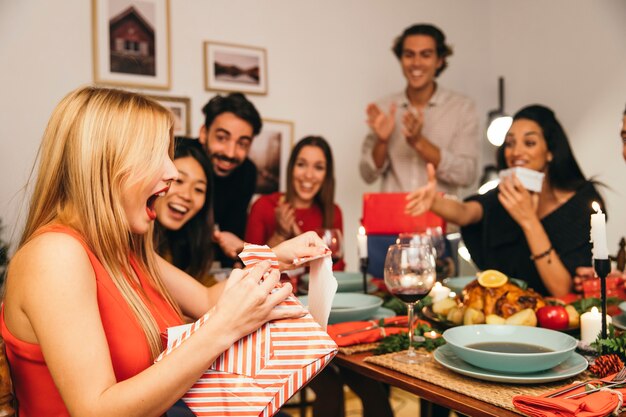 Vue de côté de la femme avec la boîte actuelle au dîner de Noël