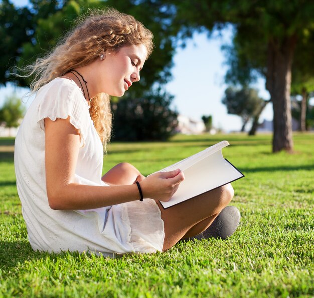 Vue de côté d&#39;une femme calme lecture dans le parc