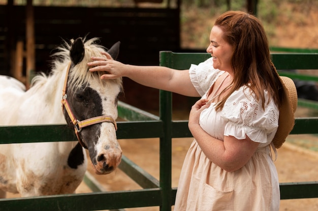 vue côté, femme, caresser, cheval