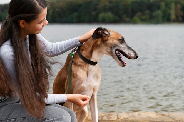 Photo gratuite vue côté, femme, caresser, chien