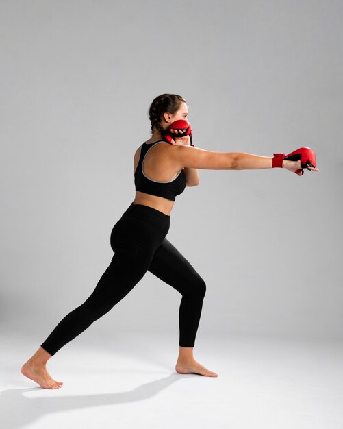 Vue côté, femme, dans, habillement fitness, poinçonnage, à, boîte gants