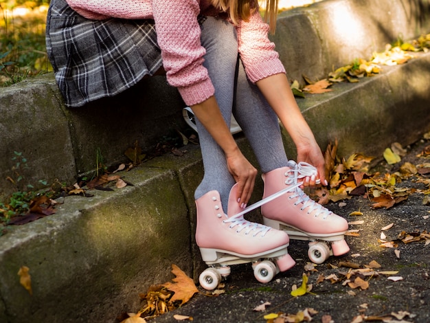 Vue côté, de, femme, dans, patins roller, et, feuilles