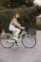 Photo gratuite vue côté, de, femme, dans, ville, vélo